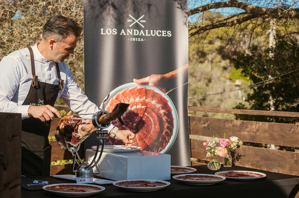 privékok snijdt jamon in een luxe villa